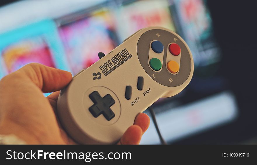 Person Holding White Snes Controller