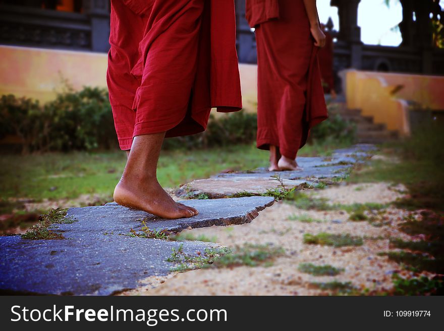 Two Human Wearing Monk Dress Walking on the Pathway