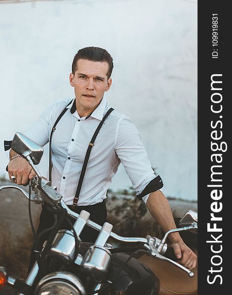 Man In White Dress Shirt With Suspenders Holding Black Motorcycle