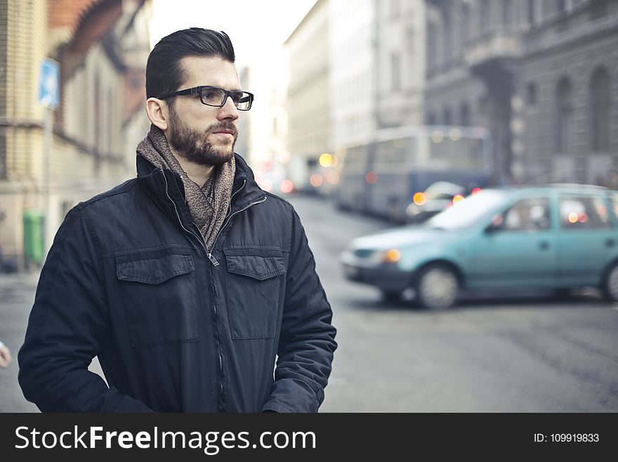 Man Wearing Black Zip-up Jacket Standing on the Street