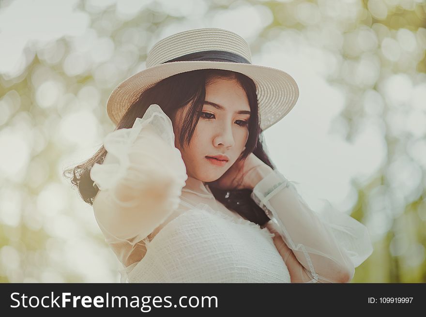 Woman Wears White Dress and Brown Hat