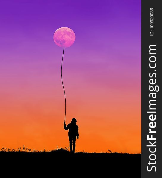 Silhouette Of Man Holding String Connected To Moon