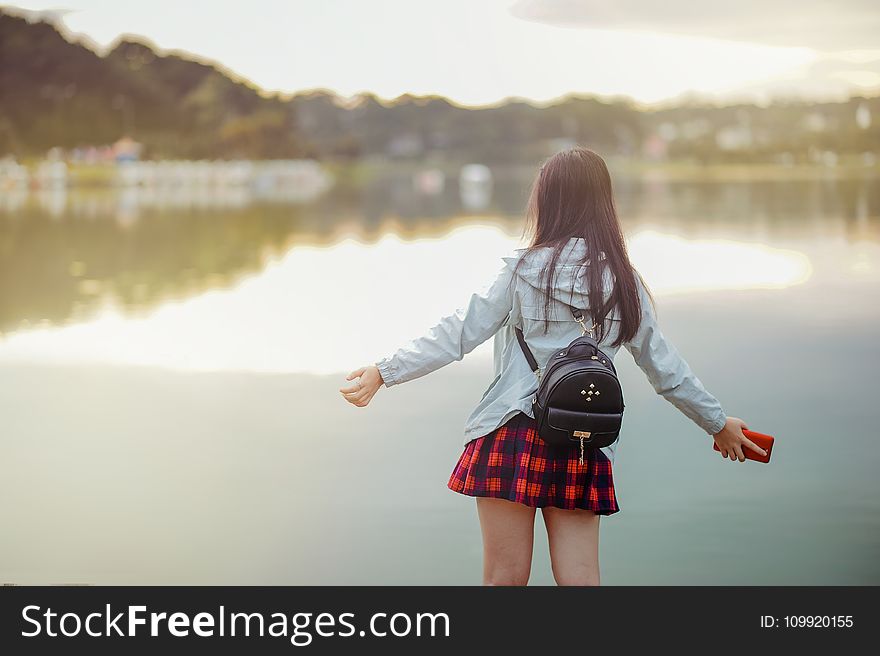 Selective Focus Photography of Girl Near Body of Water