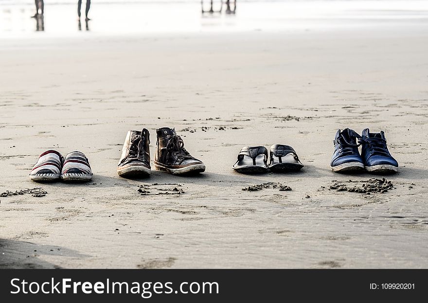 Photo of Assorted Pairs of Footwear on Sand