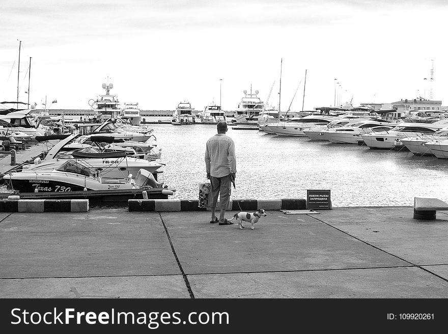 Man Standing On A Concrete Dock Near Body Of Water