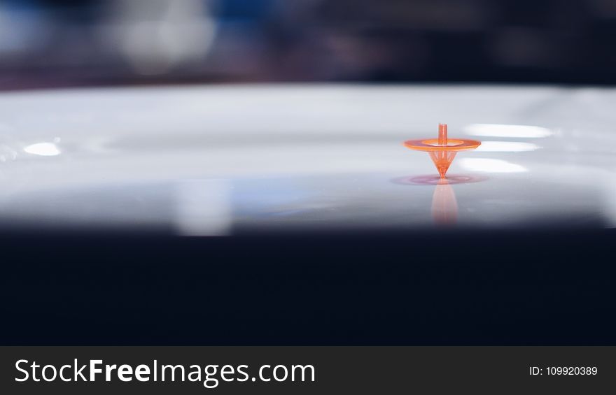 Orange Plastic Toy on White Surface