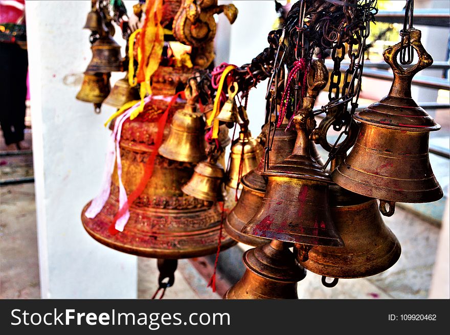 Hanged Brown Metal Bell in Close Up Photography