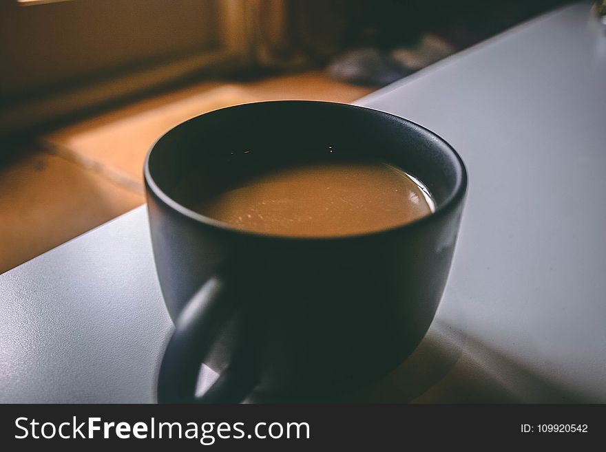 Shallow Focus Photography of Black Ceramic Mug Filled With Brown Coffee on the Table