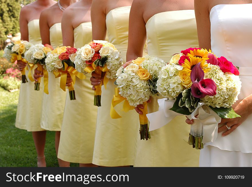 Women Wears White and Yellow Tube Strapless Dresses Holding White, Red, and Yellow Bouquet