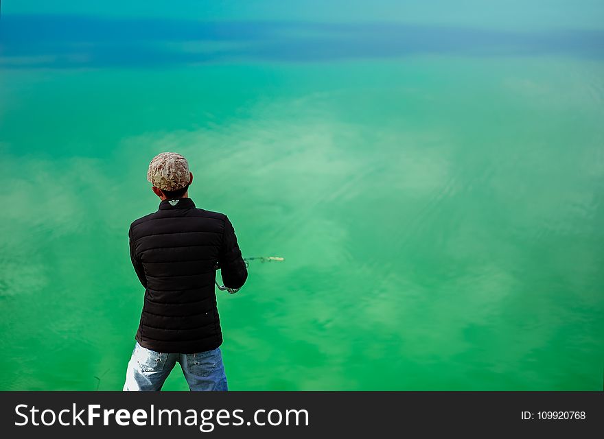 Man in Black Jacket Standing in Front of Sea