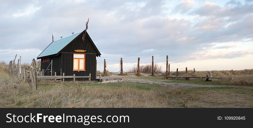 Wooden Shed With Fence Surrounded By Grass