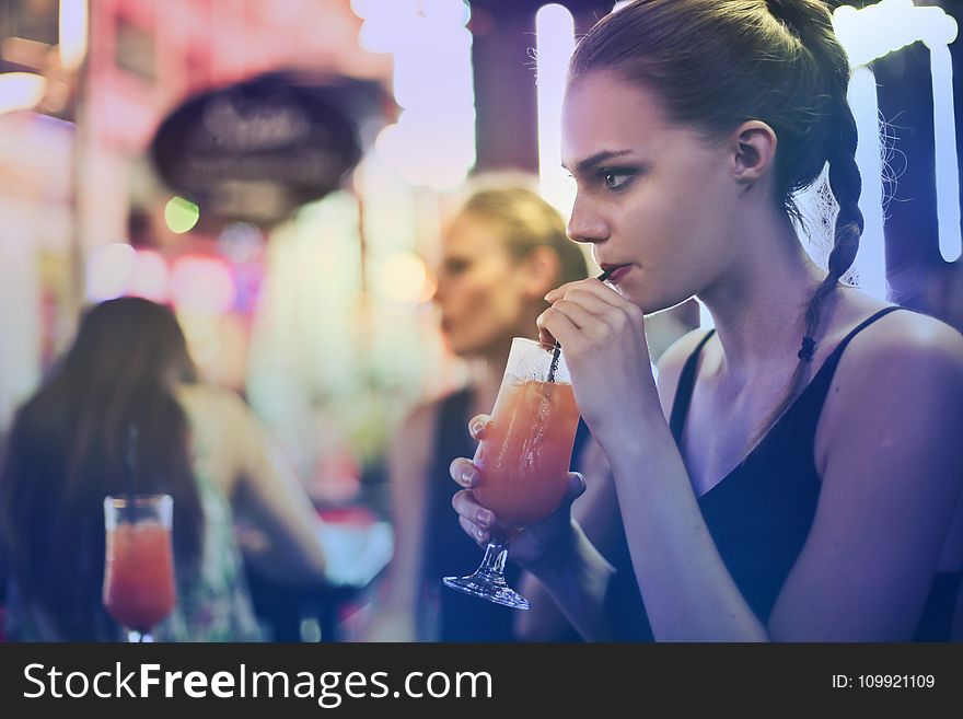 Woman Wearing Black Spaghetti Strap Top and Sipping Drink