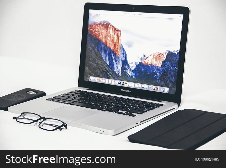 Macbook Air Beside Eyeglasses and Black Smart Case