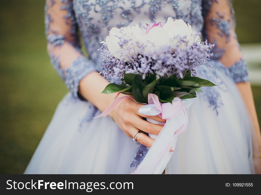 Woman in Blue Gown Holding Bouquet of Flowers