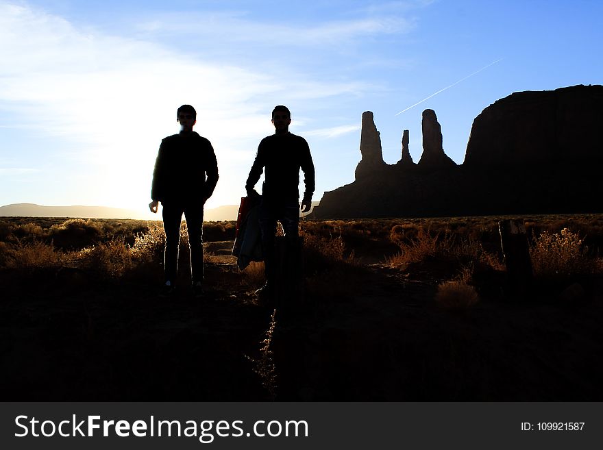 Silhouette of Two Person Standing on the Desert