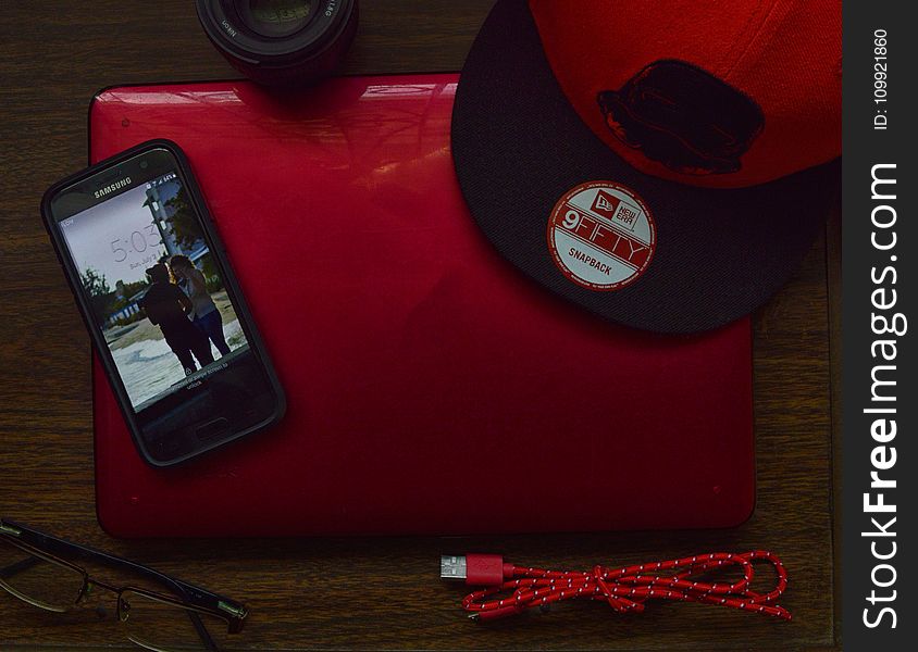 Red and Black New Era 9fifty Snapback Cap and Black Samsung Galaxy Android Smartphone