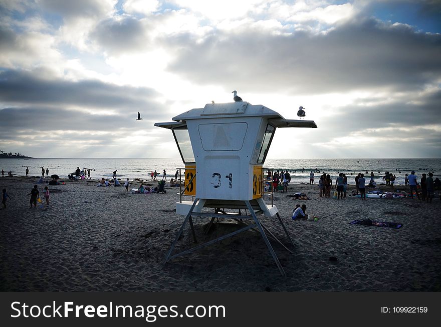 People Near Sea Under White And Blue Sky