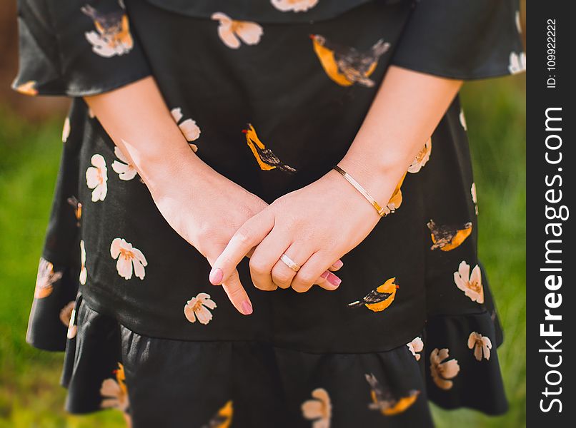 Close Up Photo of Person Wearing Black and Orange Floral Dress