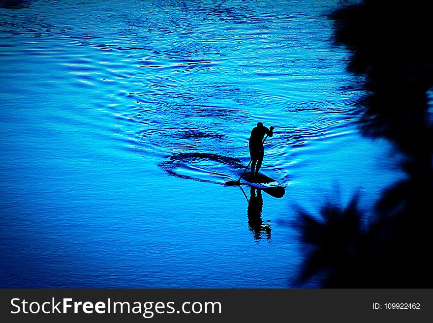 Silhouette of Person Paddling Boat