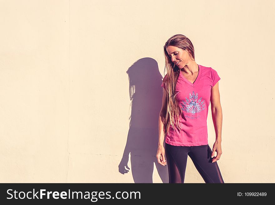 Woman in Pink V-neck Cap-sleeved Shirt Standing Near Wall