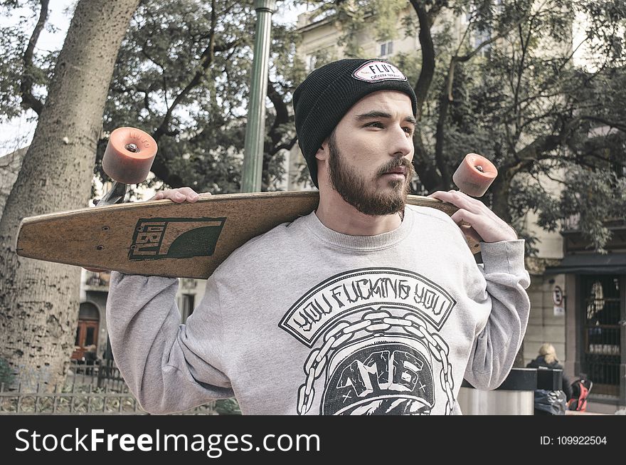 Photography of a Man Holding Longboard
