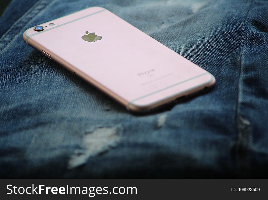 Close-Up Photography of Rose Gold Iphone 6s on Top of Blue Denim Jeans