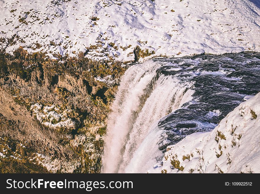 Water Falls Beside Mountains With Snow