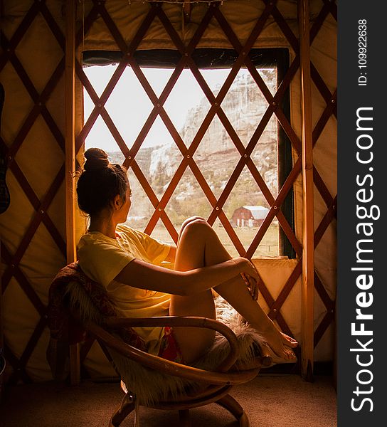 Photography Of Woman Sitting On Brown Wicker Chair During Sunset