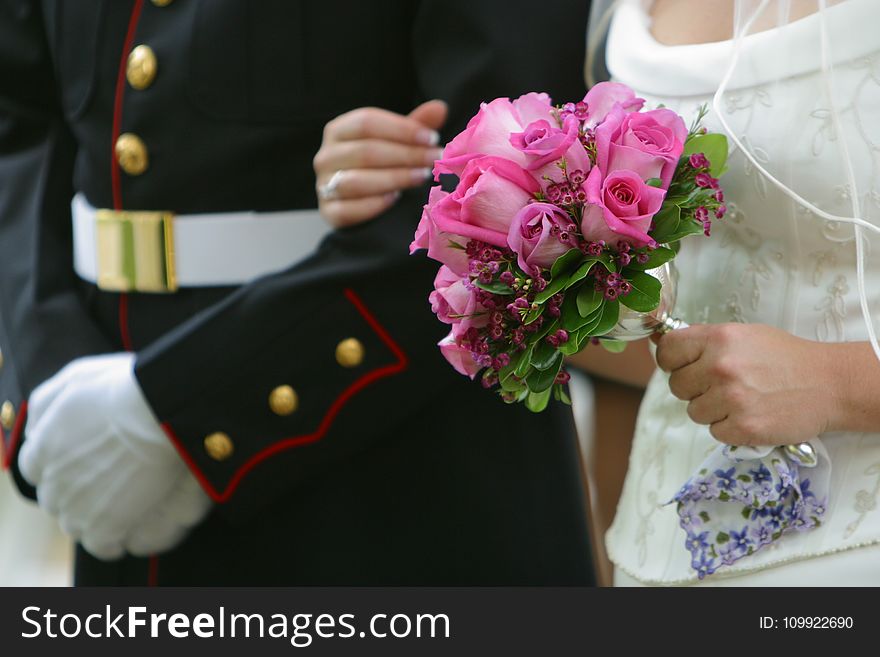 Woman Holding Pink Rose Wedding Bouquet Wearing White Wedding Dress