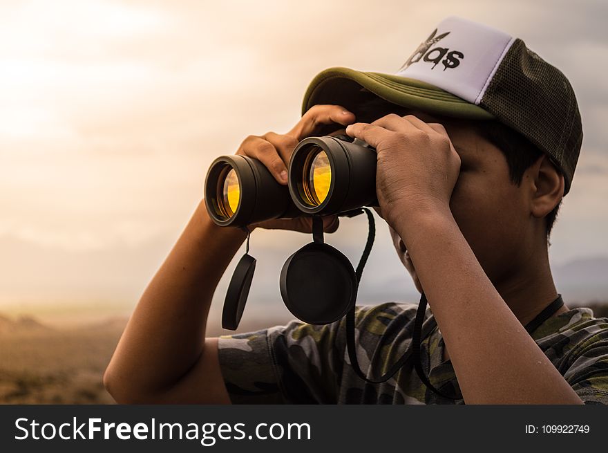 Man Looking In Binoculars During Sunset