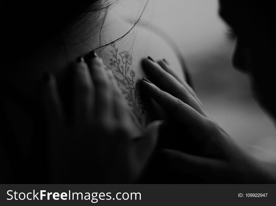 Grayscale Photo Of Man Looking At Woman&x27;s Back Flower Tattoo