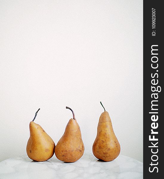 Three Brown Fruits on White Textile