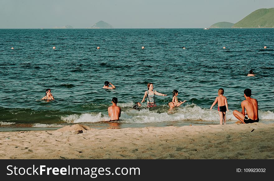 Photography of People Swimming in the Beach