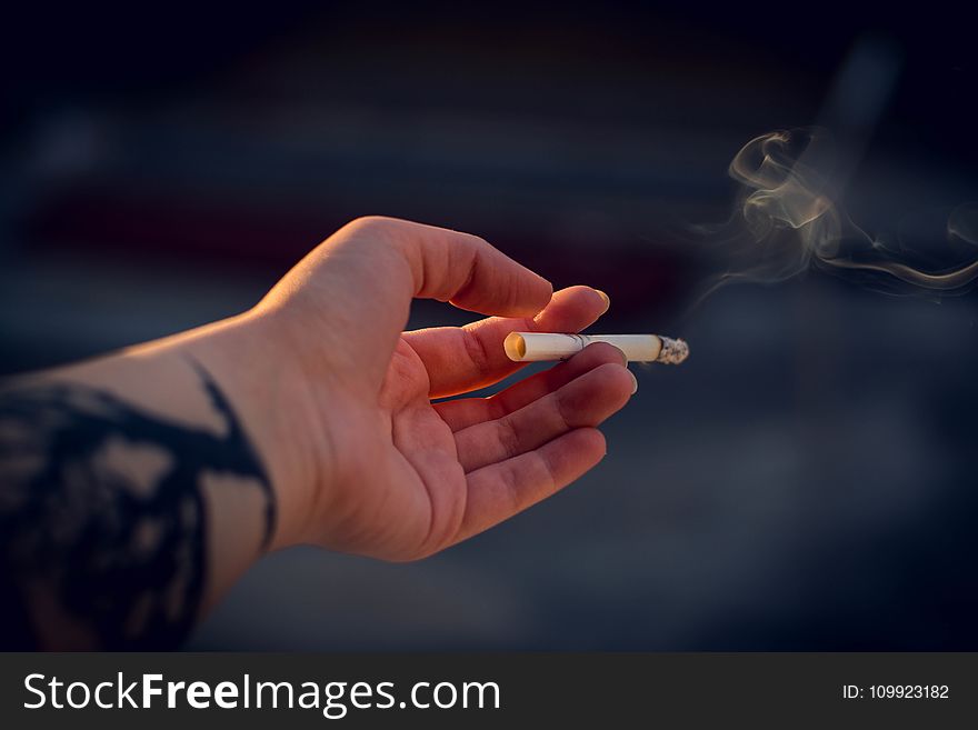 Close-Up Photography of a Person Holding Cigarette