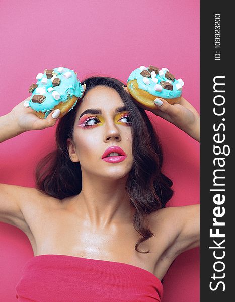 Woman in Red Tube Top Holding Two Doughnuts