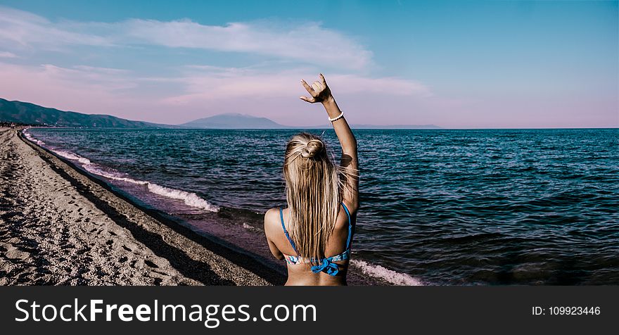 Woman in Blue Bikini Standing Beside Shore