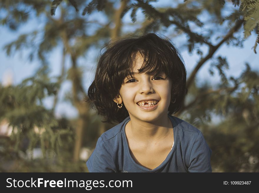 Shallow Focus Photography of Girl Wearing Blue Shirt