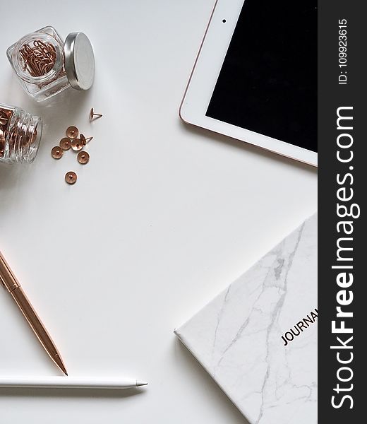 White Ipad On The Table Near Small Clear Glass Jars