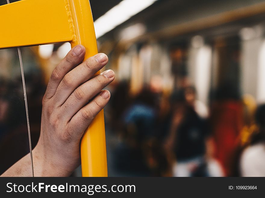 Person Holding Yellow Metal Chair