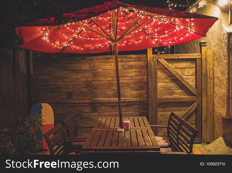 Photography Of Red Patio Table With String Lights