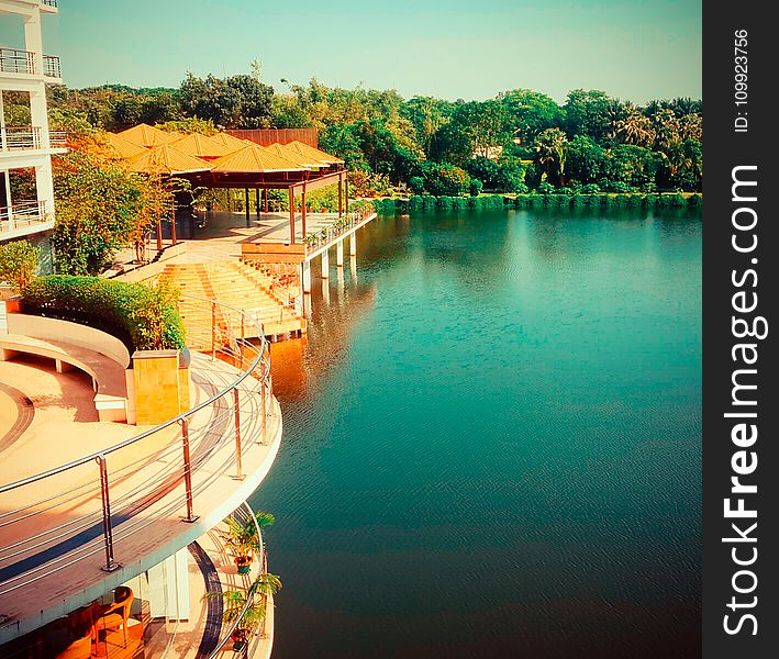 Brown Wooden House Beside Gazebos Near Body Of Water