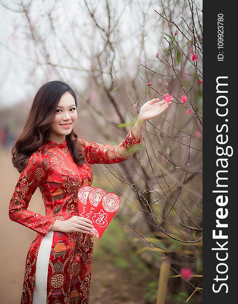 Woman Wearing Red Long-sleeved Dress Holding Pink Petaled Flower