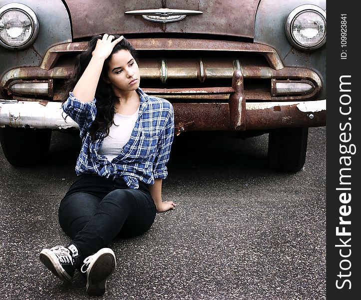 Woman In Blue Sports Shirt Sitting Infront Of Vintage Brown Car