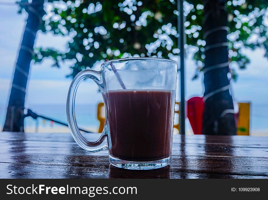Clear Glass Mug With Beverage on Brown Wooden Table