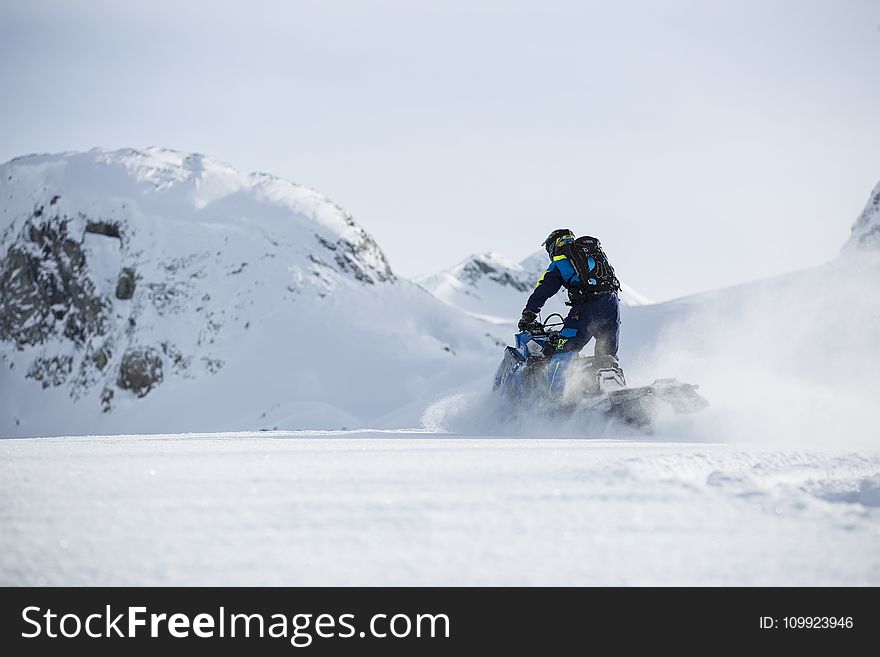 Person Riding on Snowmobile during Winter