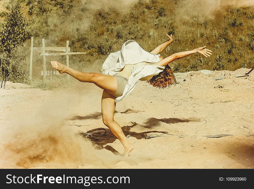 Woman Wearing White Dress Dancing on Brown Sand