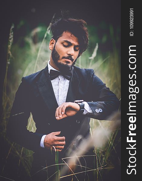 Man in Tuxedo Suit Surrounded by Grass