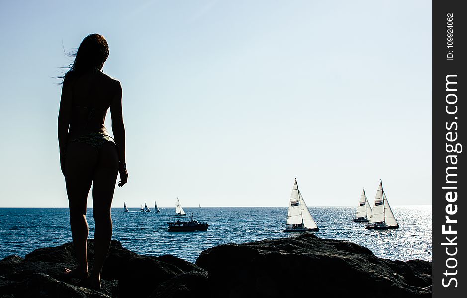 Woman Standing on Rock With Sailing Boats on Sea