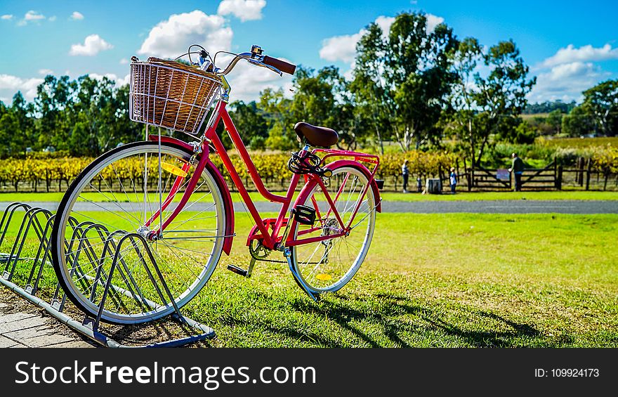 Red Cruiser Bike Parked On Metal Bike Stand