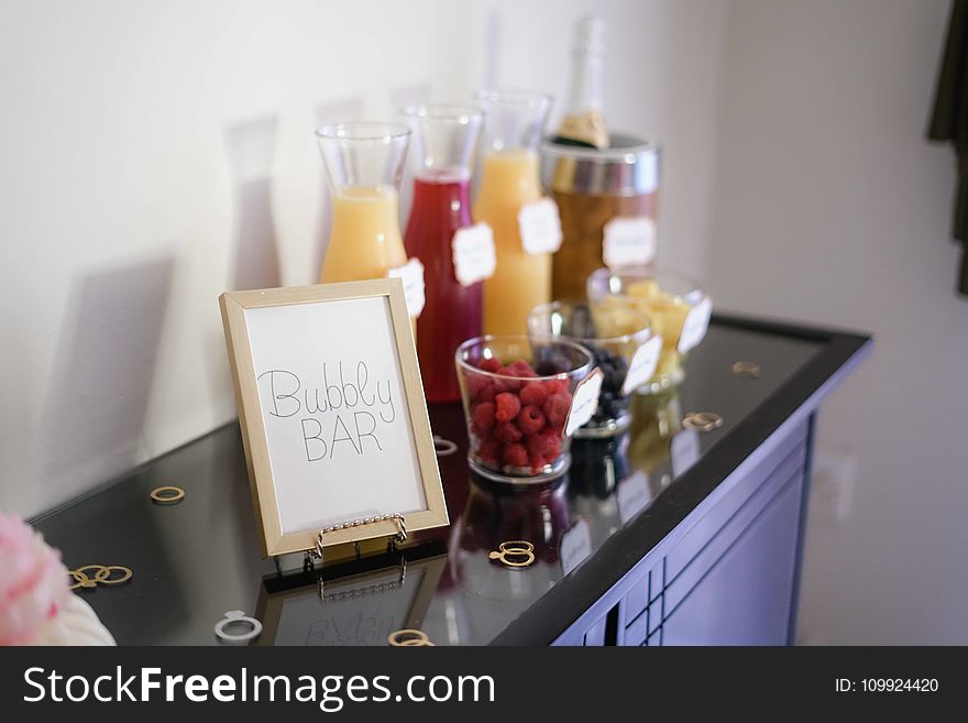 Bubbly Bar Sign With Several Assorted-color Liquid With Bottles on Top of Black Wooden Table